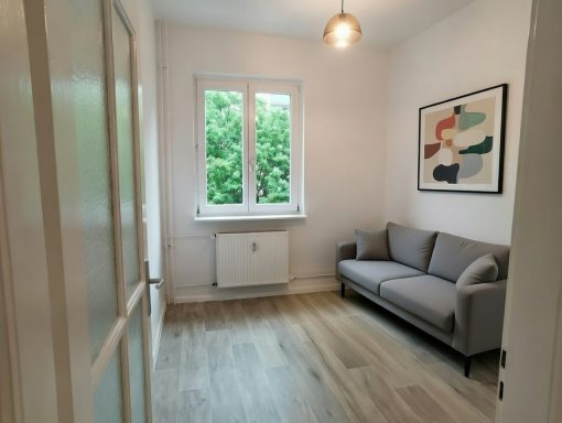 Maler- und Bodenarbeiten im Zimmer Fachgerechte Malerarbeiten in kleinem Zimmer mit lackierter Tür und neu verlegtem Laminatboden